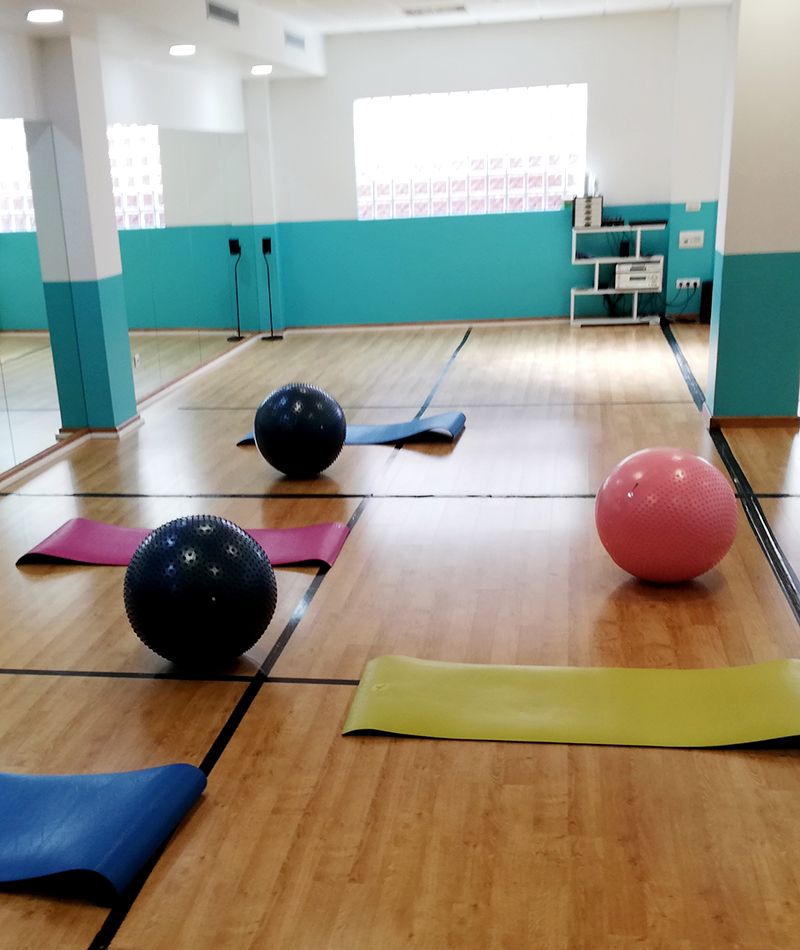 Clase vacía con las colchonetas extendidas y la fitball encima